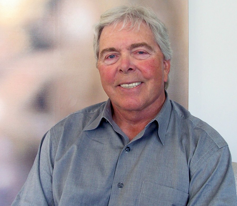 Portrait of Herbert Boyer, smiling, in a blue shirt